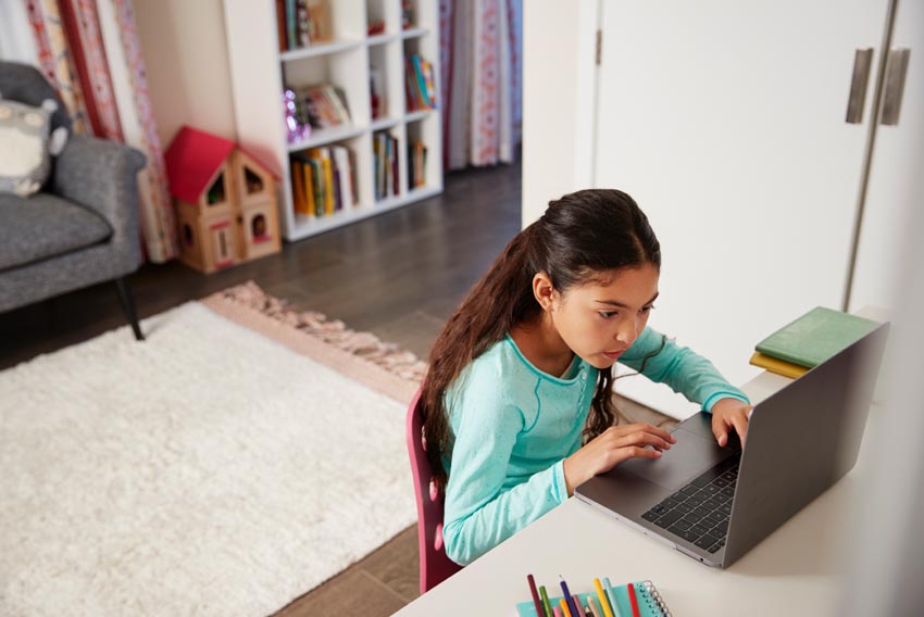 young girl sitting at desk in bedroom using AZYCUS