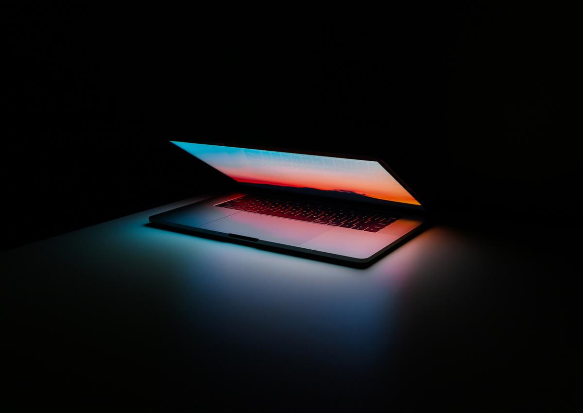 Benefits and limitations of AI in Graphic Design shown through a glowing laptop symbolizing tech-driven creativity and constraints