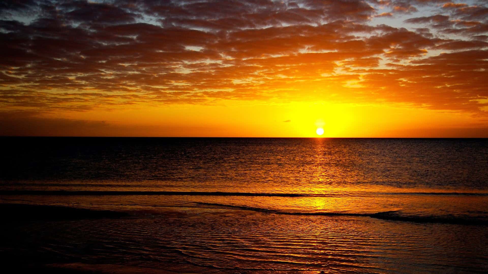 A serene sunset over a tranquil lake with vibrant colors reflecting on the water.